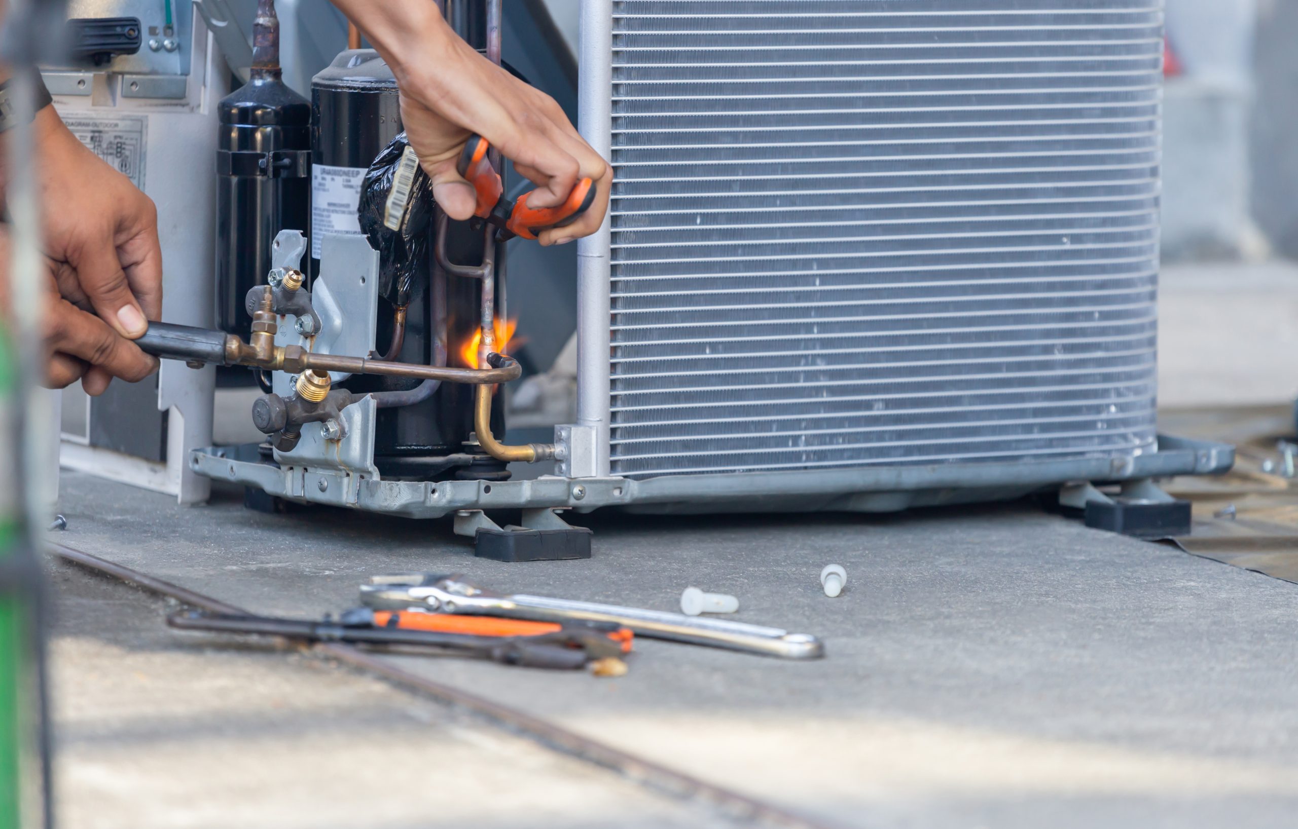 Altman’s Cooling & Heating technician performing a detailed HVAC system inspection.