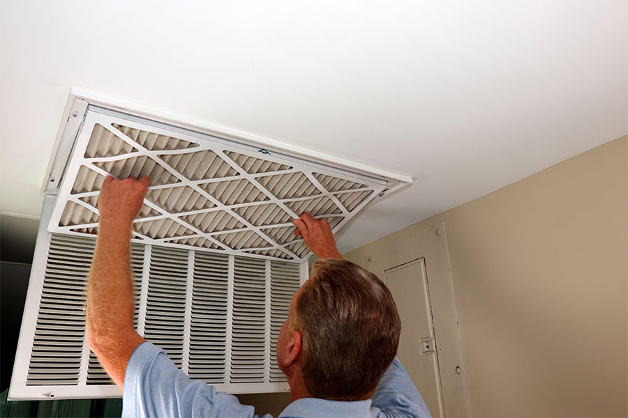 Man replacing ceiling air filter