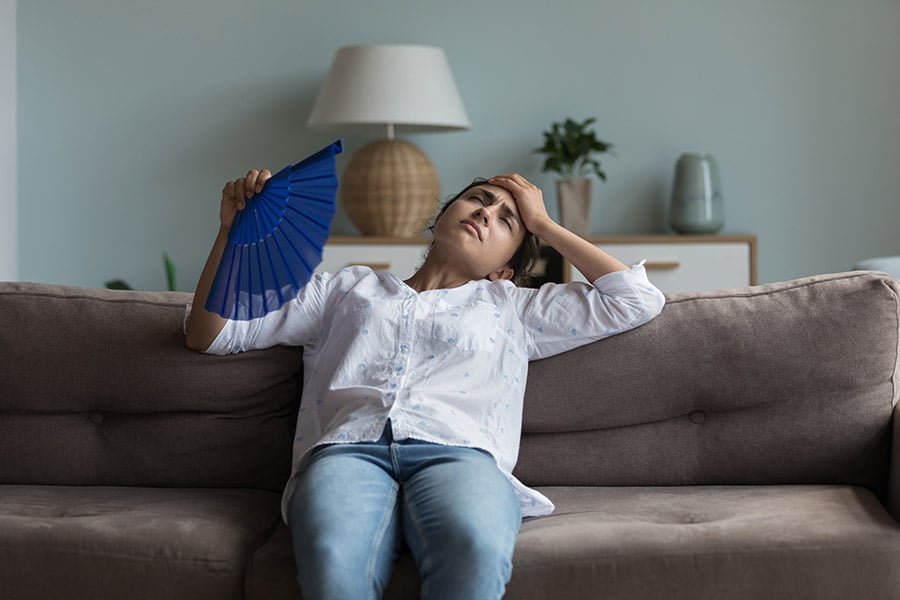 Woman fanning herself on couch