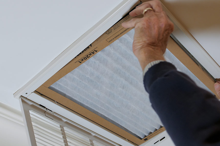 Person changing an air filter.