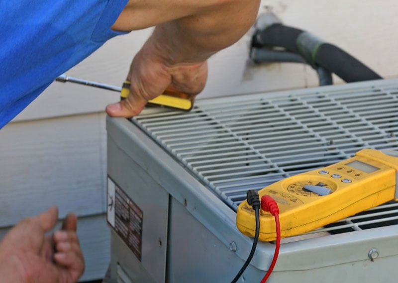 A technician performing A/C maintenance.