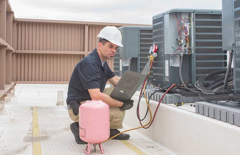 A technician working on an A/C unit.